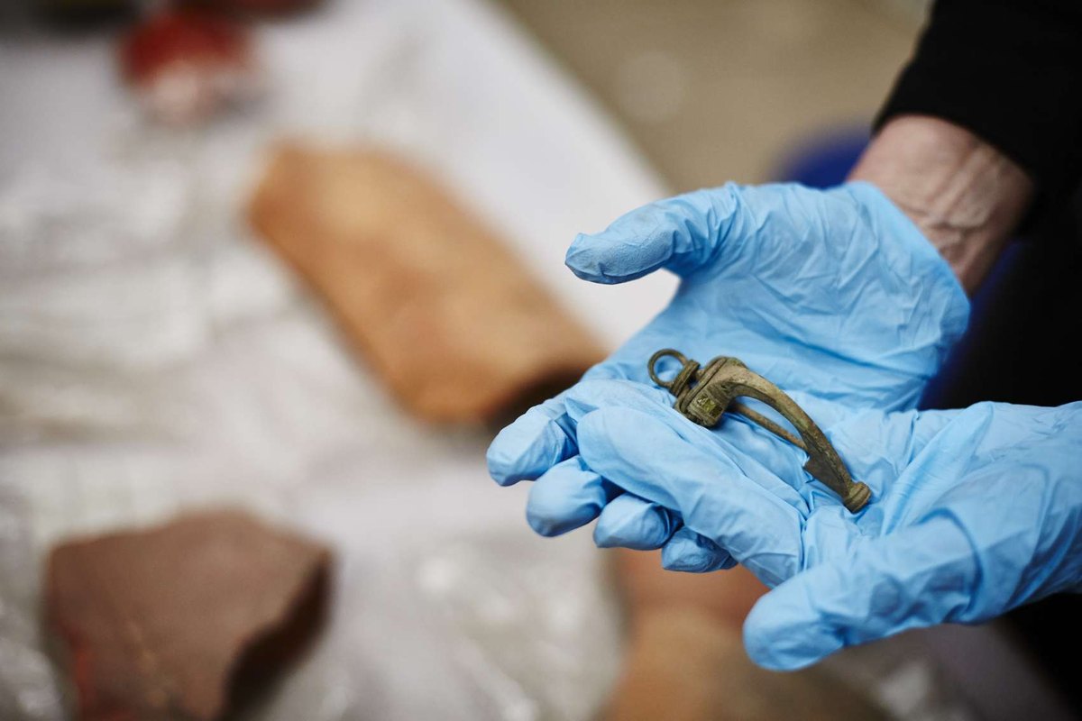 A metal find held for recording during fieldwork